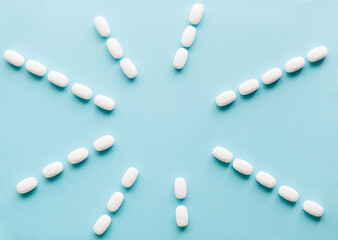 White pills on a pastel background. Capsules and round pills close-up. Healthcare and medicine.