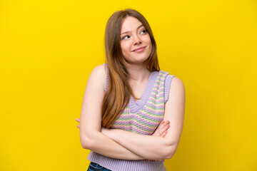 Young caucasian woman isolated on yellow background making doubts gesture while lifting the shoulders