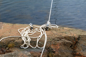 An anchorage in a granite bank with a white rope threaded through it for parking small watercraft,...