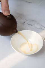 Tea from the teapot is poured into a cup. Tea ceremony concept