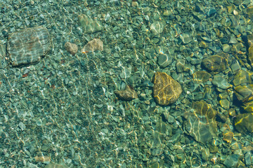 Turquoise transparent water with pebbles at the bottom. Beautiful background. - Powered by Adobe