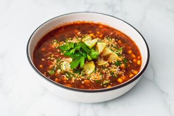 healthy plant-based food, vegan mexican-inspired soup with red kindey beans corn and coriander in spicy tomato soup