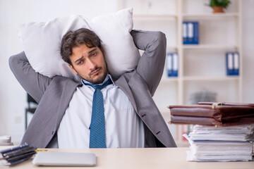 Young male employee in oversleeping concept