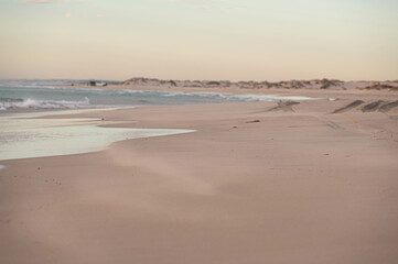 Sand flying over the beach during a sunrise