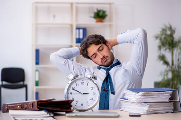 Young male employee in oversleeping concept