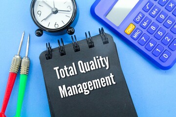 calculators, arrows, alarm clocks and notebooks with the words total quality management