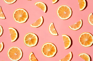 Pattern of many sliced lemons and oranges on a trendy bright pink background. Flat lay, top view. Summer freshness, detox, antioxidants, healthy lifestyle concept