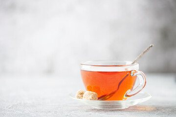 Glass cup of hot fragrant tea on a wooden background