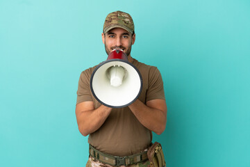 Military with dog tag over isolated on blue background shouting through a megaphone