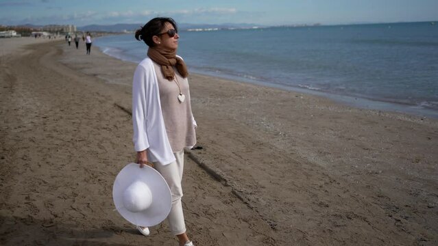 Paseo por la playa con vestido y pamela blanca.