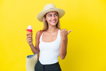 Blonde Uruguayan girl in summertime holding ice cream isolated on yellow background pointing to the side to present a product