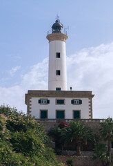 Lighthouse in the port of Ibiza. Beautiful lighthouse painted white on a sunny day. View of the Ibiza lighthouse from below. 