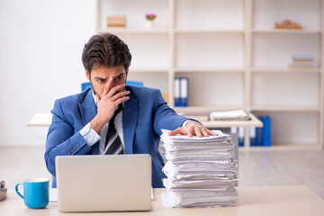 Young male employee and too much work in the office