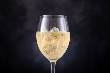 Weißwein eiskalt im Glas mit Trauben und Eiswürfel