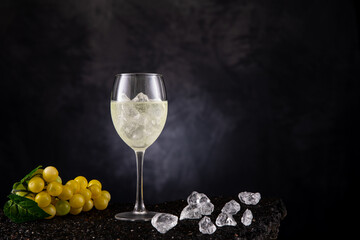 Weißwein eiskalt im Glas mit Trauben und Eiswürfel