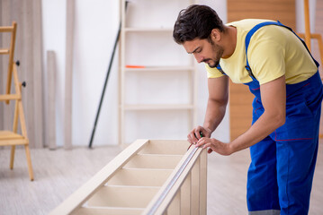 Young male carpenter working at home