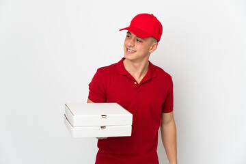 Pizza delivery man with work uniform picking up pizza boxes isolated on white background looking to...