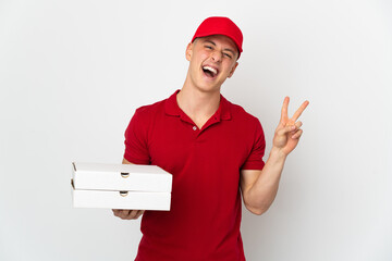 Pizza delivery man with work uniform picking up pizza boxes isolated on white background smiling and showing victory sign