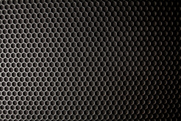 Abstract background is a black metal grid for the speaker close-up. Details audio equipment. Soft focus. Black iron speaker grid texture - obrazy, fototapety, plakaty