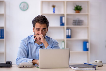 Young male call center operator working at his desk