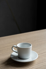 White coffee cup on a saucer on a wooden table