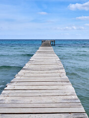 Wooden pier in the Mediterranean in Playa de Muro. Muro beach in the Bay of Alcudia, Majorca, Balearic Islands, Spain