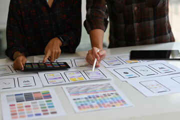 Close up Creative Ux developer and Ui designer brainstorming about mobile app interface wireframe...
