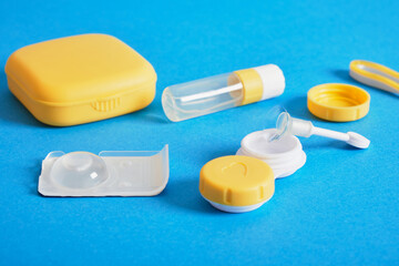 Contact lenses set, plastic case on blue background with copy space