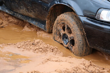 Dark blue car stuck in mud after floods caused by storm