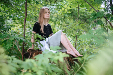 Practice of meditation and interaction with nature. Girl in green forest