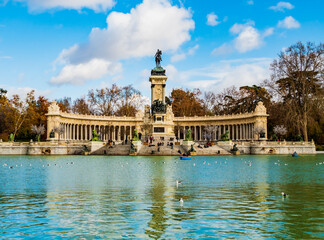 Fototapeta na wymiar Lake, boats and the Alfonso XII monument in the Buen Retiro Park, the largest public garden in Madrid, Spain 