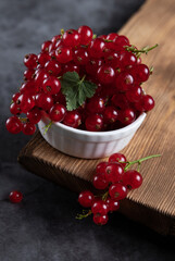 Red current in a small cup, standing on a wooden table