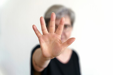 Eine Frau schützt sich mit abwehrender Handbewegung