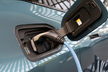 Close up of electric car with a connected charging cable 