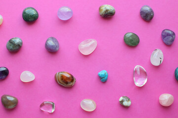 Gems of various colors. Amethyst, rose quartz, agate, apatite, aventurine, olivine, turquoise, rock crystal on pink background