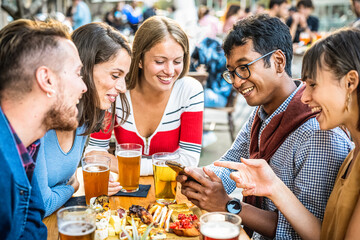 young people having fun at beer pub, millennials people drinking and eating at restaurant, young students using smart devices for being active on social media