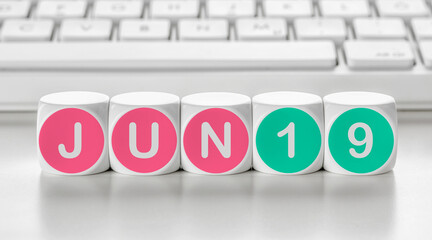Letter dice in front of a keyboard - June 19