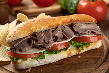 Submarine sandwich with roast beef, cheese, tomato and lettuce