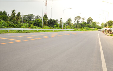 Asphalt concrete pavement road with yellow line, guardrail,traffic lane line and traffic island.Empty concrete road.