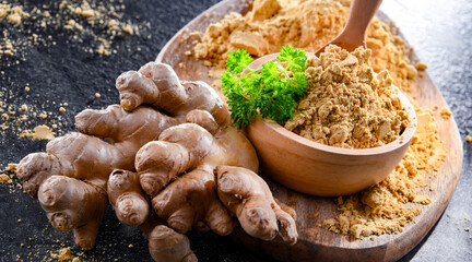 A bowl with ground ginger and its fresh rhizome
