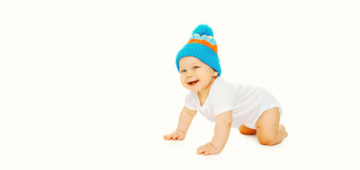Happy cheerful laughing little baby crawling in hat on the floor on white background, banner blank copy space for advertising text