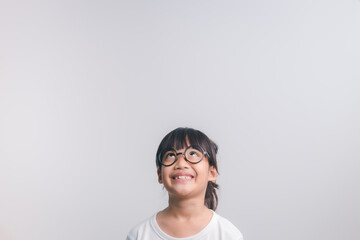 Cheerful young asian girl posing with looking up, studio shot
