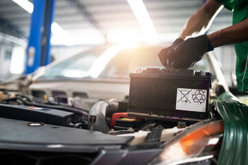 mechanic changing car battery An engineer is replacing a car battery because the car battery is dead. concept car care