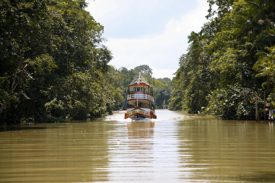 Small ferry boat in the waters of the Guajar&aacute; River, entering Combu Island July, 2019.