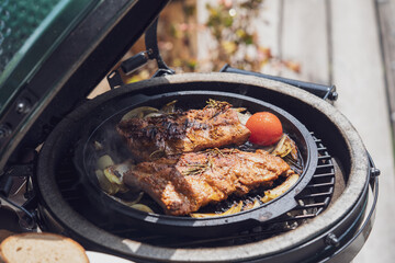 smoking spareribs and onions on a ceramic grill with charcoal