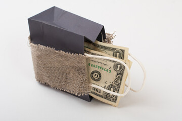 Designer paper bag, close up, dollars inside, isolated on white background