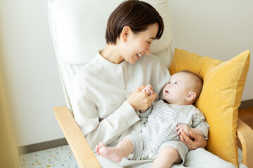 Fototapeta na wymiar 椅子に座ってリラックスする赤ちゃんと母親