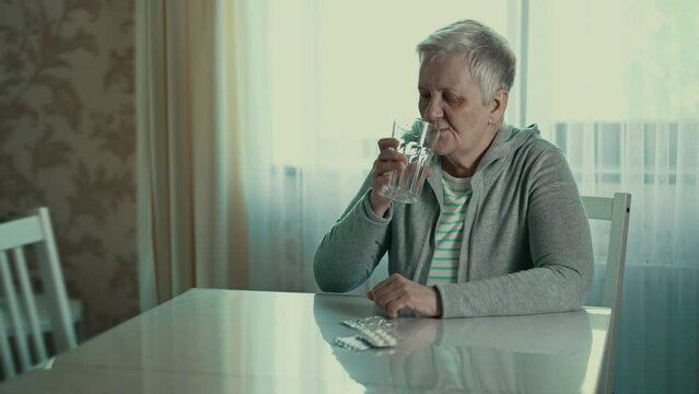 Old woman taking a pill