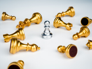 A silver pawn chess piece standing alone in the middle of many fallen silver pawn chess pieces on white background. Stand out from the crowd. Leadership, Unique, survivor, winner, difference concept.