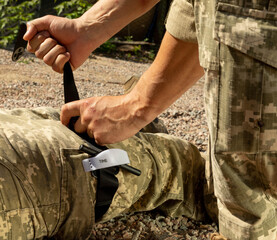 Army medics practice applying a tourniquet to the leg of a wounded soldier. Combat tactical...